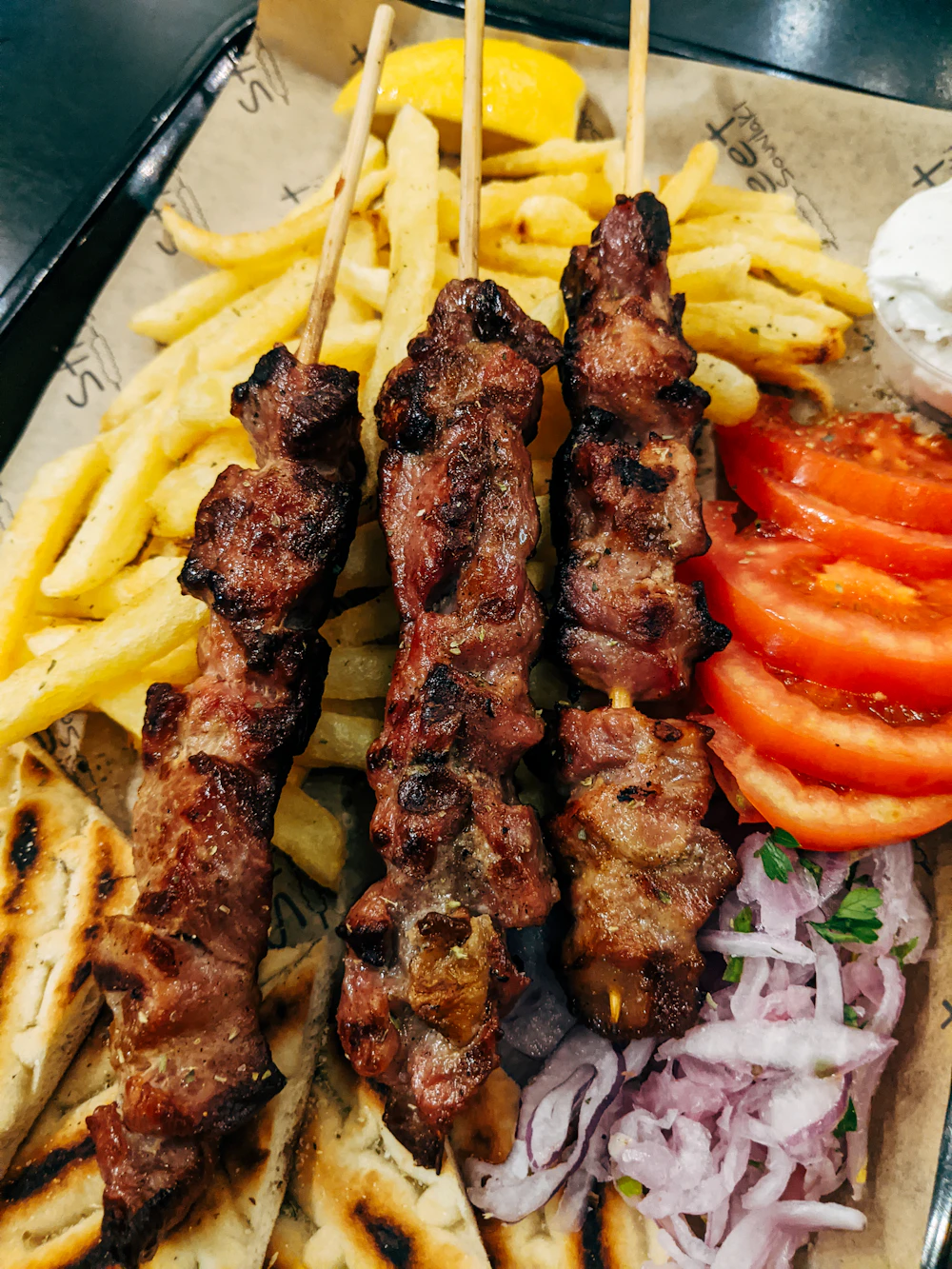 Grilled kebab skewers with fries and tomatoes